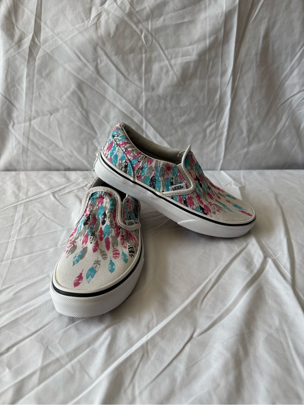 Vans Kids Slip-On Sneakers in White with Pink & Teal Feather Print